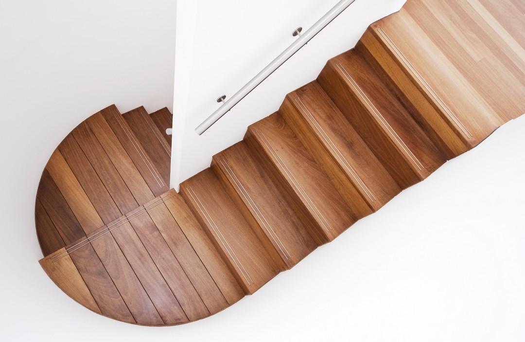 Escaliers en bois dans un intérieur blanc immaculé.