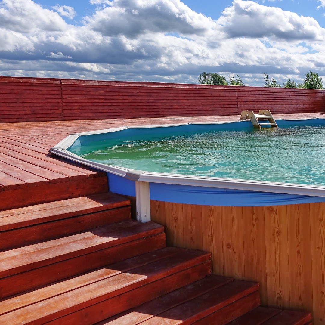 Escalier en bois qui donne sur une piscine.