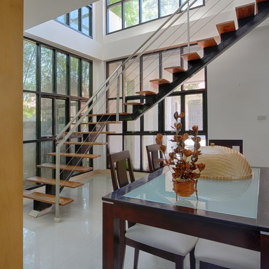 Intérieur avec un escalier suspendu au milieu de la pièce.